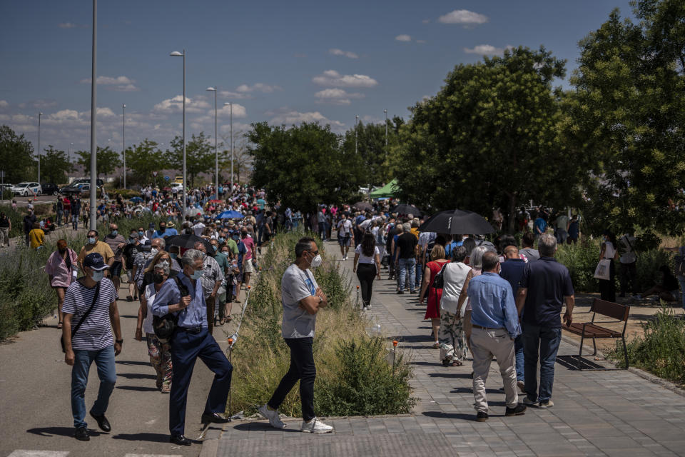 Hundreds of people queue to be vaccinated against COVID-19 at the Enfermera Isabel Zendal Hospital in Madrid, Spain, Tuesday, July 7, 2021. Spain is trying to stamp out a new wave of COVID-19 among its youth thanks to a robust vaccination program that is widely supported. Spain like the rest of the European Union got off to a slow start to compared to the United States and Britain when the first vaccines were released. But it has quickly made up ground once deliveries by drug makers started flowing. (AP Photo/Olmo Calvo)