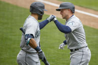 Seattle Mariners' Kyle Seager, right, celebrates with Jose Marmolejos, left, his solo home run against the Minnesota Twins in the sixth inning of a baseball game Sunday, April 11, 2021, in Minneapolis. (AP Photo/Bruce Kluckhohn)