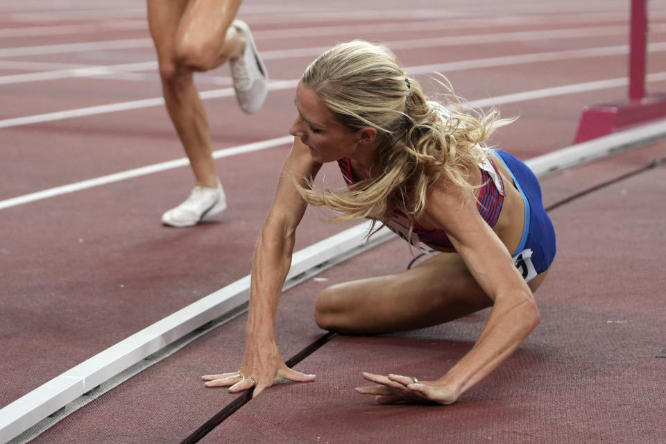 Emma Coburn, of the United States, falls in the final of the women's 3,000-meters steeplechase at the 2020 Summer Olympics, Wednesday, Aug. 4, 2021, in Tokyo. (AP Photo/Matthias Schrader)