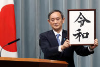 FILE - In this April 1, 2019, file photo, Japan's Chief Cabinet Secretary Yoshihide Suga unveils the name of new era "Reiwa" at the prime minister's office in Tokyo. Japan's Parliament elected Suga as prime minister Wednesday, Sept. 16, 2020, replacing long-serving leader Shinzo Abe with his right-hand man. (AP Photo/Eugene Hoshiko, File)