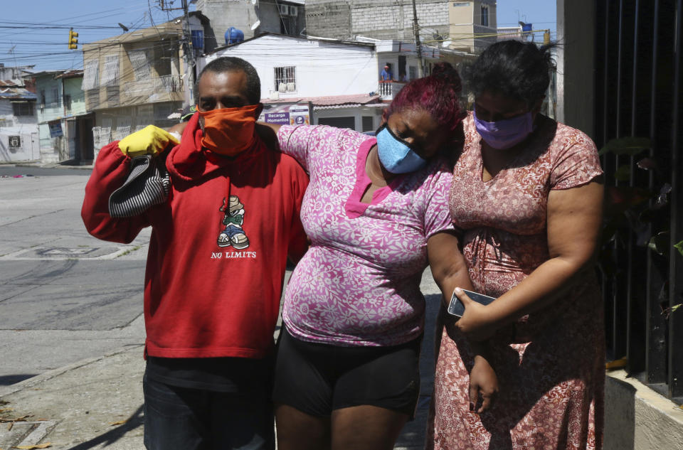 FILE - In this April 16, 2020 file photo, Mariela Jacome, right, helps her mother Catherine Quinonez who Mariela says is experiencing symptoms associated with COVID-19, as they arrive to a hospital in Guayaquil, Ecuador. In March and April, Guayaquil was a pandemic hellscape of makeshift morgues, hundreds dying at home, bodies left in the street. But Guayaquil has stabilized since then, sending medical teams and equipment elsewhere in Ecuador and taking in virus patients from outside the city. (AP Photo/Angel de Jesus, File)