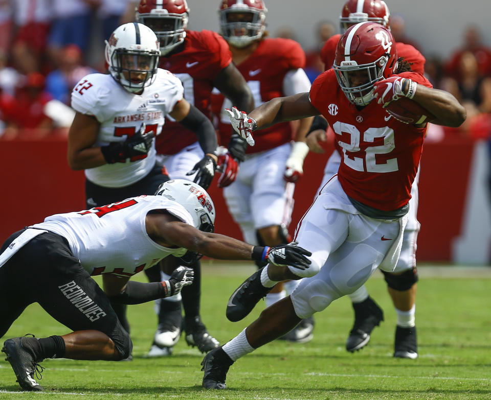 Alabama running back Najee Harris (22) eludes the tackle of Arkansas State defensive back Darreon Jackson (34) as he carries the ball during the first half of an NCAA college football game, Saturday, Sept. 8, 2018, in Tuscaloosa, Ala. (AP Photo/Butch Dill)