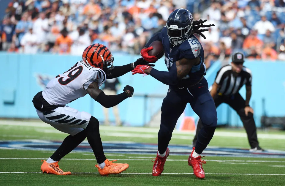 Oct 1, 2023; Nashville, Tennessee, USA; Tennessee Titans running back Derrick Henry (22) breaks a tackle attempt by Cincinnati Bengals cornerback Cam Taylor-Britt (29) during the second half at Nissan Stadium.