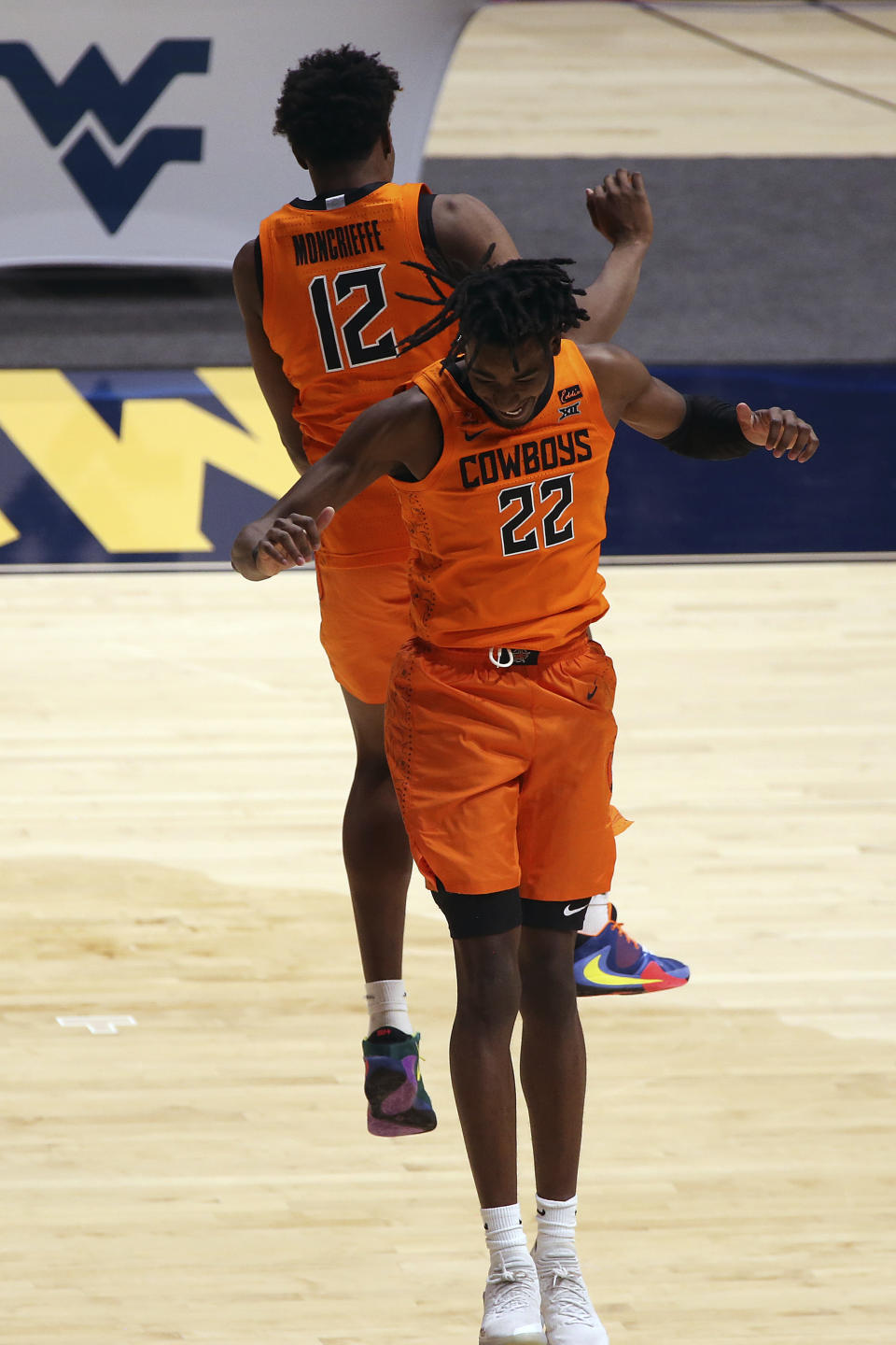 Oklahoma State forwards Matthew-Alexander Moncrieffe (12) and Kalib Boone (22) celebrate after a win against West Virginia in an NCAA college basketball game Saturday, March 6, 2021, in Morgantown, W.Va. (AP Photo/Kathleen Batten)