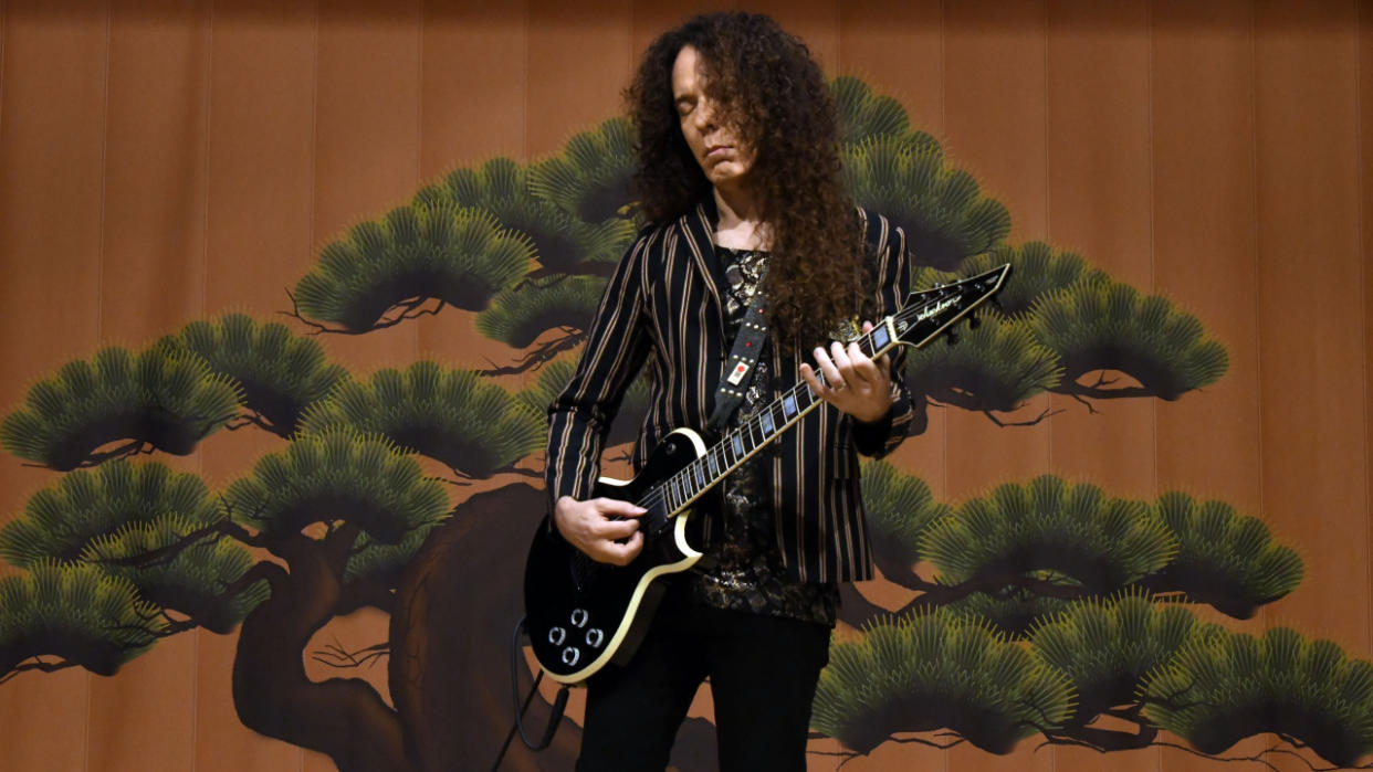  Marty Friedman playing guitar onstage. 