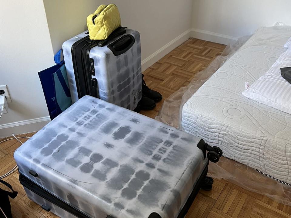 Pauline Villegas' suitcases and mattress lying on the floor in her bare bedroom.