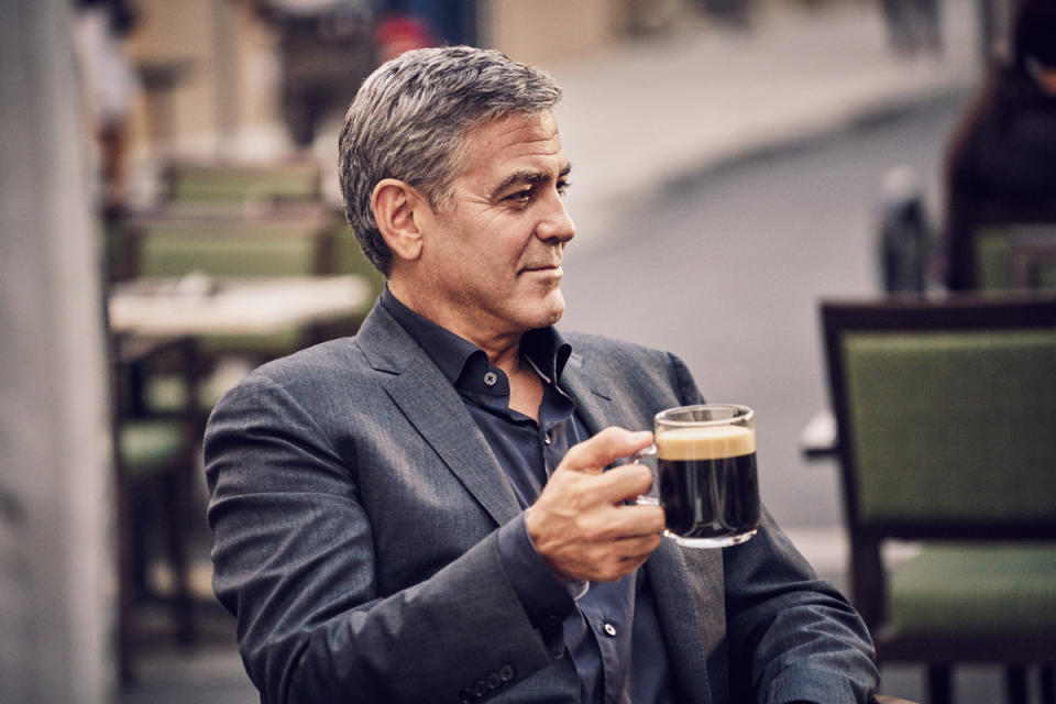 George Clooney drinks a cup of coffee