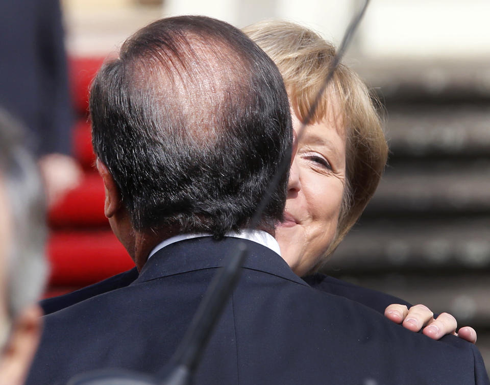 German Chancellor Angela Merkel, right, and French President Francois Hollande welcome each other in front of the castle in Ludwigsburg, Germany, Saturday, Sept. 22, 2012. Merkel and Hollande attend the celebration of the 50th anniversary of former French President Charles de Gaulle's speech to the youth of Germany. (AP Photo/Michael Probst)