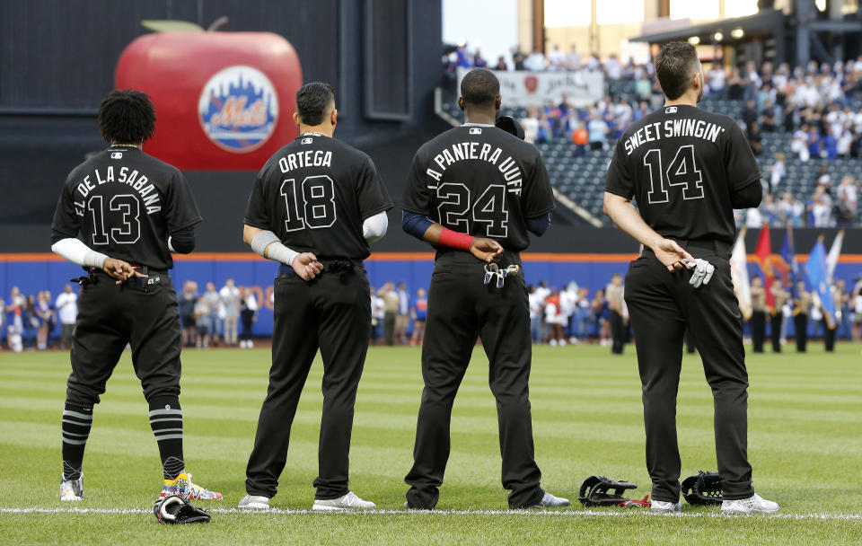 NEW YORK, NEW YORK - AUGUST 23:   Ronald Acuna Jr. #13, Rafael Ortega #18, Adeiny Hechavarria #24 and Matt Joyce #14 of the Atlanta Braves stand during the national anthem prior to a game against the New York Mets at Citi Field on August 23, 2019 in New York City. Teams are wearing special color schemed uniforms with players choosing nicknames to display for Players' Weekend. (Photo by Jim McIsaac/Getty Images)