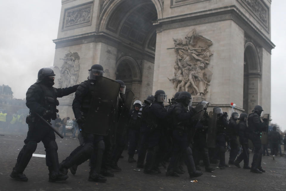 Riot police take position around the Arc de Triomphe during clashes with yellow vest protesters, in Paris, France, Saturday, Jan. 12, 2019. Authorities deployed 80,000 security forces nationwide for a ninth straight weekend of anti-government protests. (AP Photo/Thibault Camus)