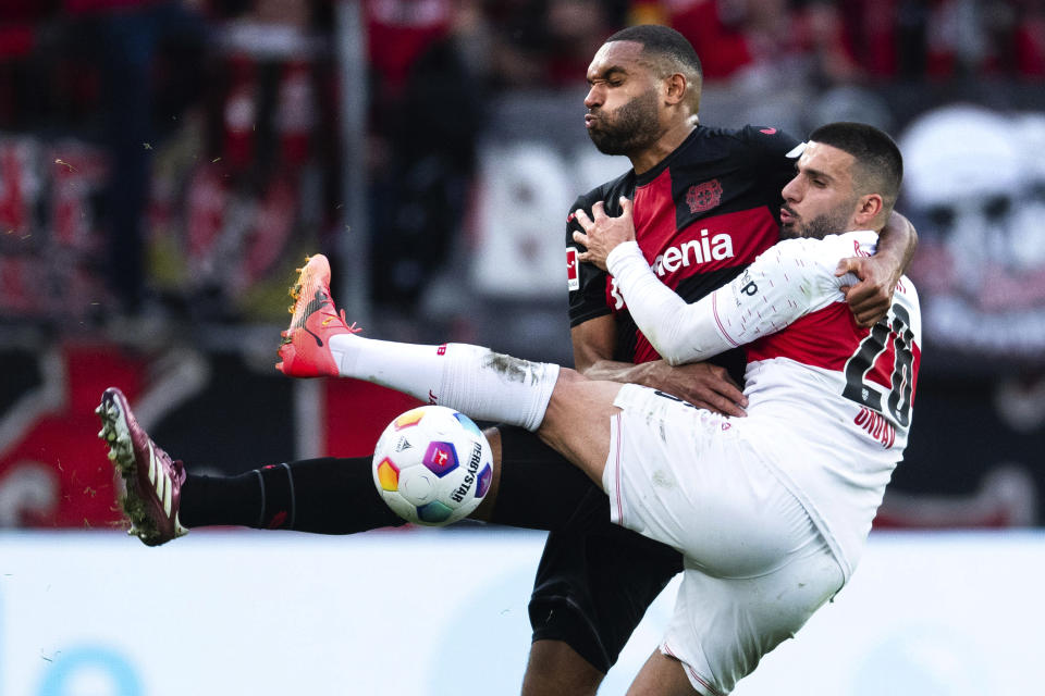 Leverkusen's Jonathan Tah, left, and Stuttgart's Deniz Undav, right, challenge for the ball during German Bundesliga soccer match between Bayer 04 Leverkusen and VfB Stuttgart in Leverkusen, Germany, Saturday, April 27, 2024. (Marius Becker/dpa via AP)