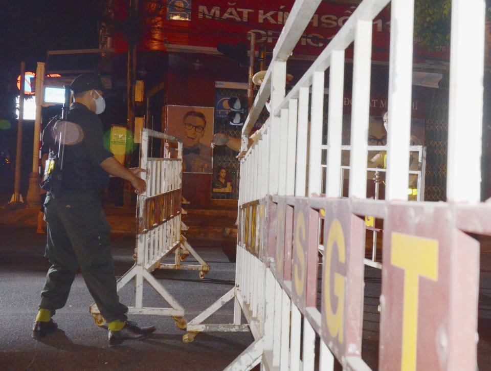 A security officer sets up barricades in Da Nang, Vietnam, early on Tuesday, July 28, 2020. Vietnam on Tuesday locked down its third-largest city for two weeks after more than a dozen cases of COVID-19 were found in a hospital. (Trinh Quoc Dung/VNA via AP)