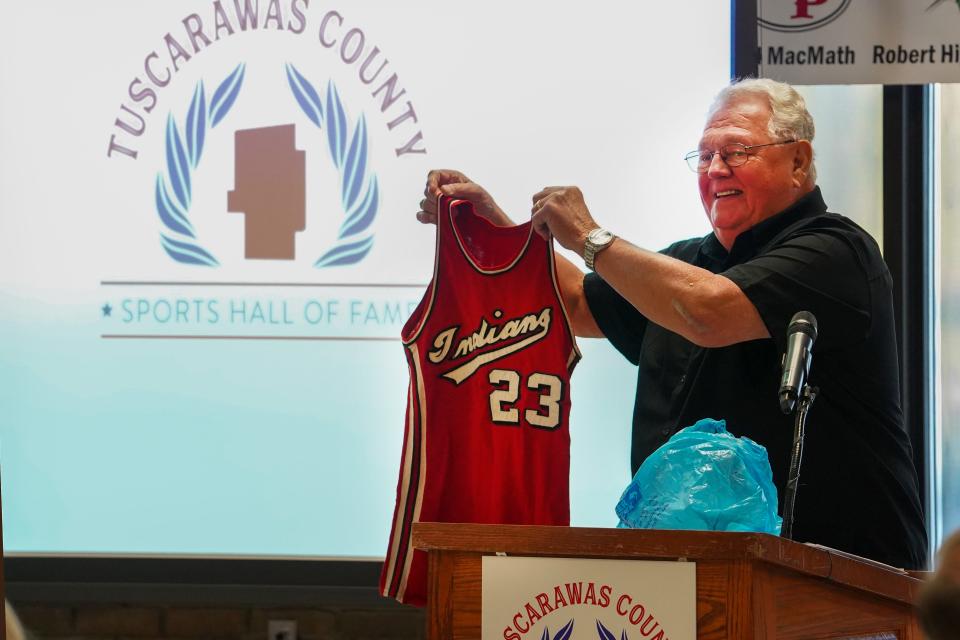 Gnadenhutten graduate Dan Jinks shows off his playing jersey from the Gnadenhutten Indians during Saturday night's Tuscarawas County Sports Hall of Fame inductions.