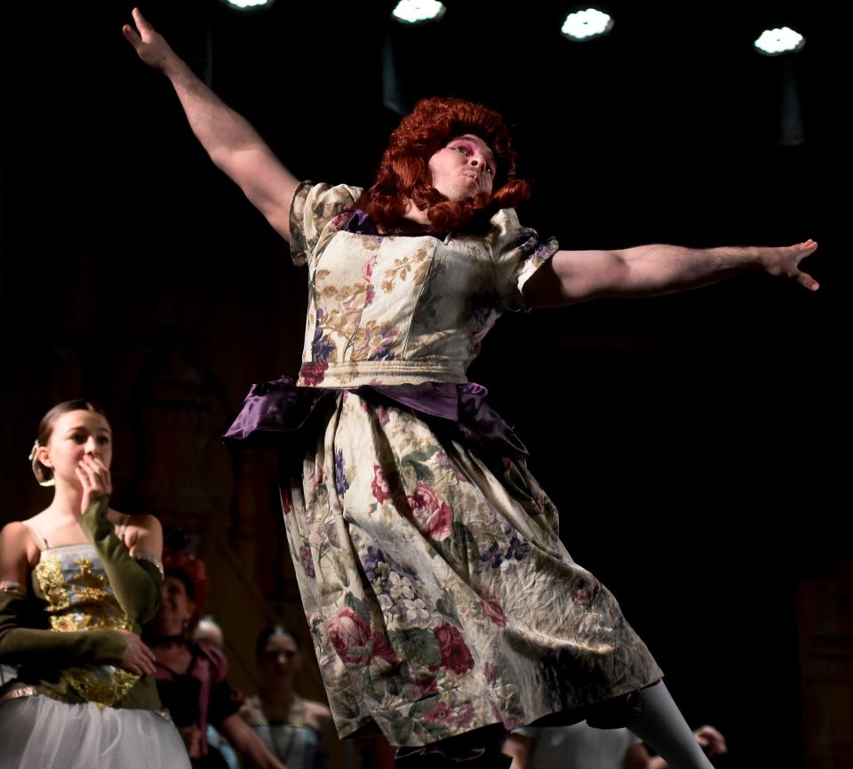 Josh Mohler of Monroe as a stepsister in the production of "Cinderella" leaps into the air as he takes part in the ballroom dance.