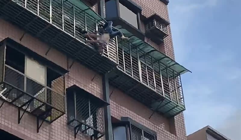 女子倒掛在4樓外牆，讓鄰居嚇壞報警。（圖／翻攝畫面）