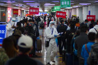 Passengers from Wuhan stand in lines designating where they will quarantine in Beijing, China, on Wednesday, April 15, 2020. Wuhan, the city at the center of the global coronavirus epidemic, lifted a 76-day lockdown and allowed people to leave for destinations across China. (AP Photo/Sam McNeil)