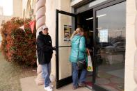 Market manager Carl Hart opens the door for a customer at the Farmers Public Market in Oklahoma City