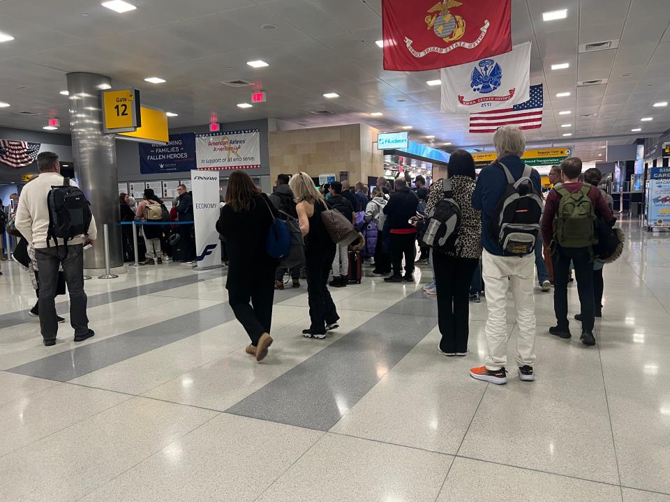 Boarding gate 12 with people standing around.