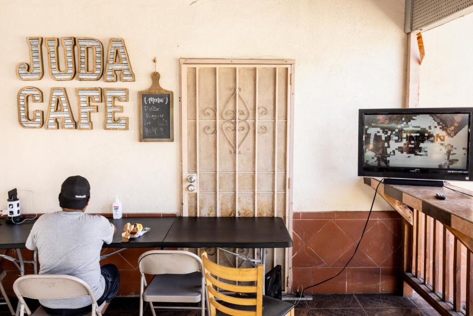 A communal kitchen area with a table and chairs and a TV