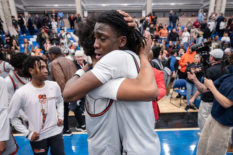 North High's Amaren Minor, left, and Teshaun Steele embrace after the Polar Bears topped Xaverian, 60-52, in overtime in a Division 1 state semifinal on Wednesday at UMass-Boston.
