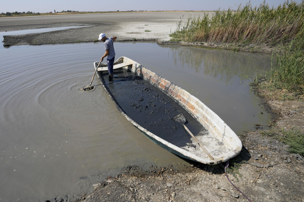 A man collects mud to be used in medical therapy from the Rusanda salty lake that has dried out completely, near Melenci, Serbia, Wednesday, Sept. 4, 2024. Experts say the summer of 2024 in the Balkans was the hottest since measurements started more than 130 years ago. (AP Photo/Darko Vojinovic)