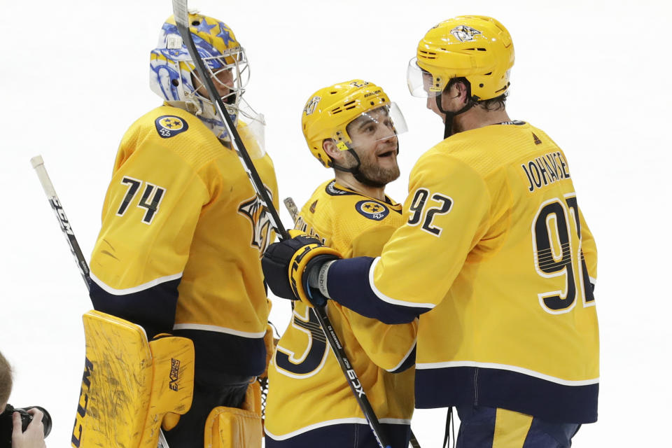 Nashville Predators right wing Rocco Grimaldi (23) is congratulated by center Ryan Johansen (92) after Grimaldi scored the winning goal against the Columbus Blue Jackets in a shootout during an NHL hockey game Saturday, Feb. 22, 2020, in Nashville, Tenn. At left is Predators goaltender Juuse Saros (74), of Finland. The Predators won 4-3. (AP Photo/Mark Humphrey)