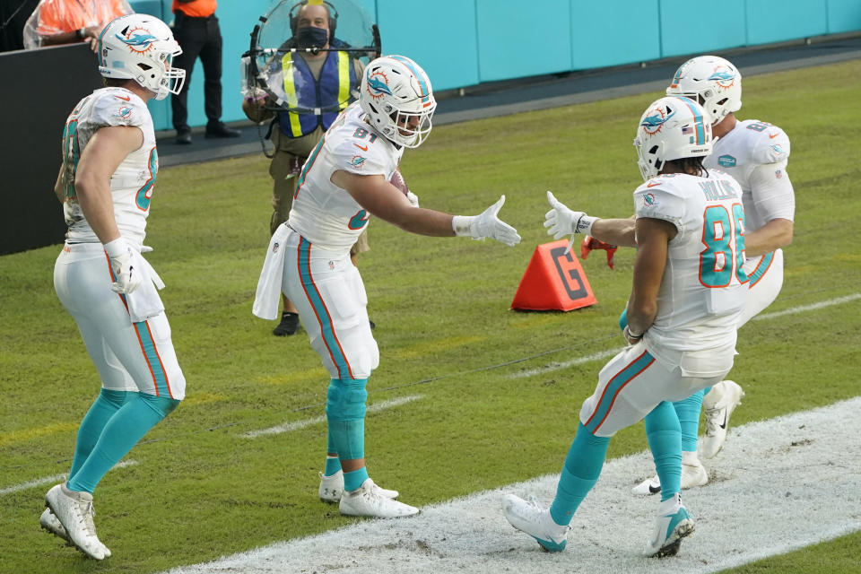 Miami Dolphins tight end Durham Smythe (81) is congratulated by wide receiver Mack Hollins (86) after Smythe scored a touchdown, during the first half of an NFL football game against the New York Jets, Sunday, Oct. 18, 2020, in Miami Gardens, Fla. (AP Photo/Wilfredo Lee)