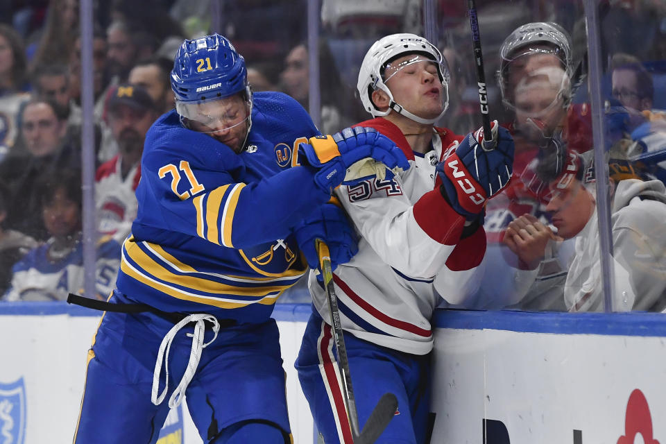 Buffalo Sabres right wing Kyle Okposo, left, checks Montreal Canadiens defensemen Jordan Harris into the boards during the second period of an NHL hockey game in Buffalo, N.Y., Monday, Oct. 23, 2023. (AP Photo/Adrian Kraus)