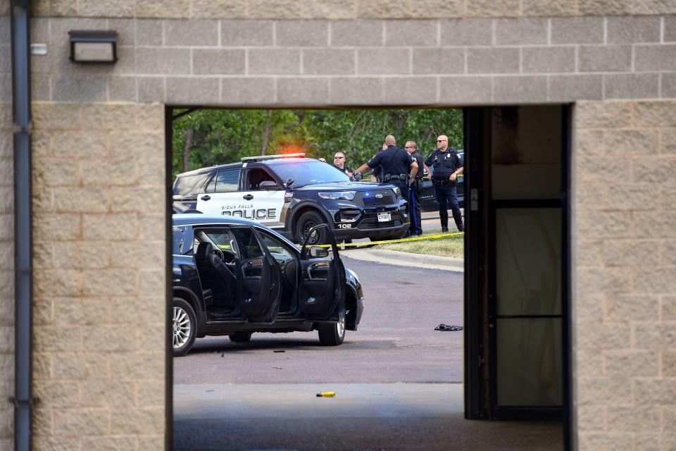 The scene of an officer-involved shooting is scene through the open doors of a car wash on Monday, July 11, 2022, at the H2Ose It car wash on Cleveland Avenue in Sioux Falls.