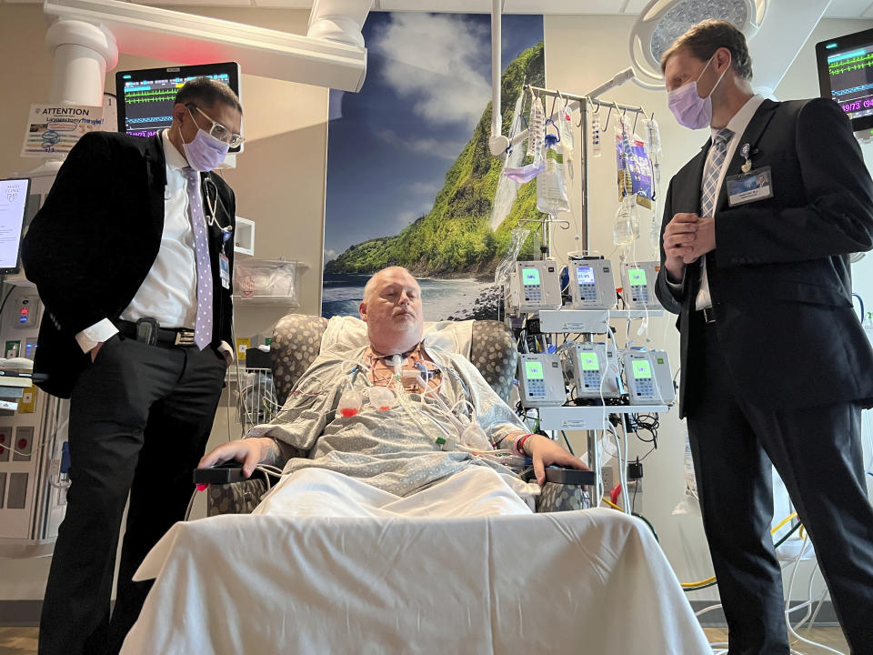 In this photo provided by the Mayo Clinic, Dr. Girish Mour, left, medical director of Mayo Clinic's Larynx and Trachea Transplant Program, and Dr. David Lott, right, standing on either side of Marty Kedian one week after his transplant surgery in Phoenix, March 8, 2024. Kedian regained his voice after surgeons removed his cancerous larynx and, in a pioneering move, immediately replaced it with a donated one. (Mayo Clinic via AP)