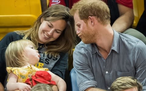 rince Harry (R) sits with David Henson's wife Hayley Henson (L) and daugther Emily Henson - Credit: Samir Hussein/WireImage