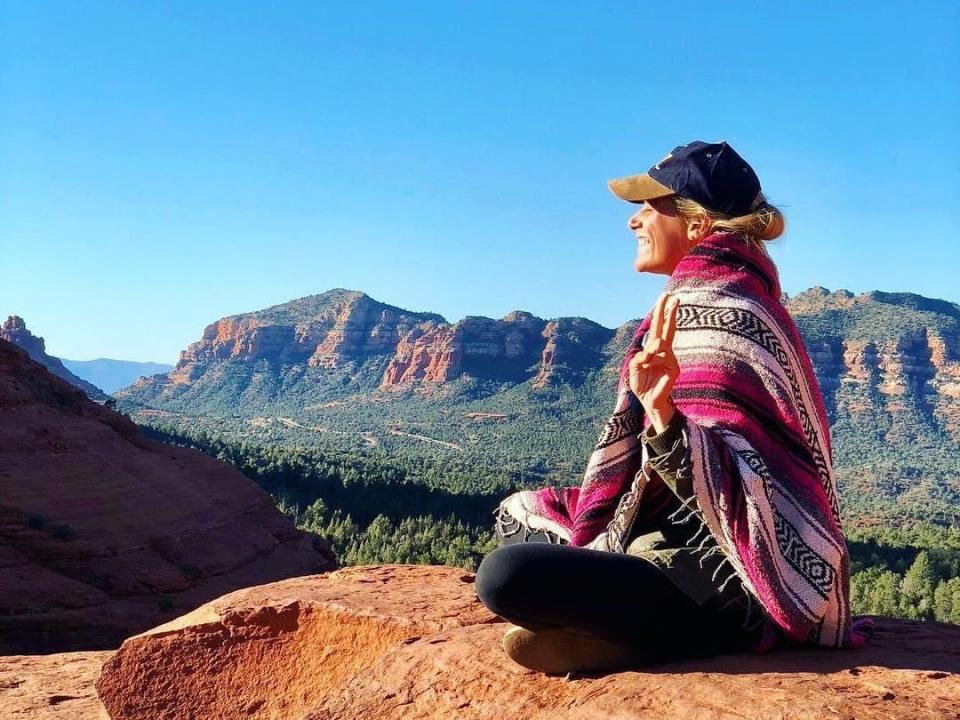 the writer sitting on red rocks