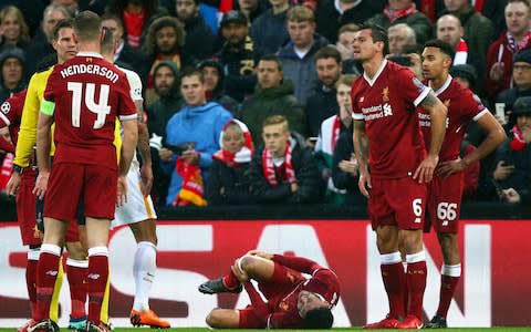 Alex Oxlade-Chamberlain grimaces on the ground after getting injured during the Champions League semifinal, first leg - Credit: Dave Thompson/AP
