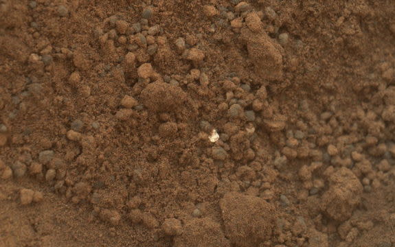 This image shows part of the small pit or bite created when NASA's Mars rover Curiosity collected its second scoop of Martian soil at a sandy patch called "Rocknest." This image was taken by the Mars Hand Lens Imager (MAHLI) camera on Curiosity