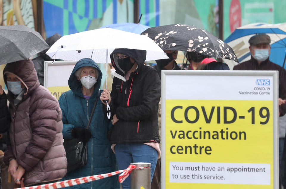 People queue in bad weather to enter a COVID-19 vaccination centre in Folkestone, Kent, during England's third national lockdown to curb the spread of coronavirus. Picture date: Friday January 29, 2021.