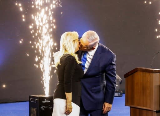 Israeli Prime Minister Benjamin Netanyahu kisses his wife Sara on election night, celebrating a victory that puts him on a path to become the country's longest-serving prime minister