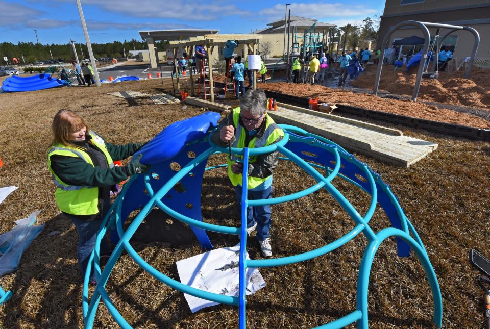 In 2018, Speedway volunteers Deb Donahue and Billy Chandler work to assemble an igloo-shaped climbing structure before it is installed in the playground at the YMCA at Baptist North in Jacksonville.