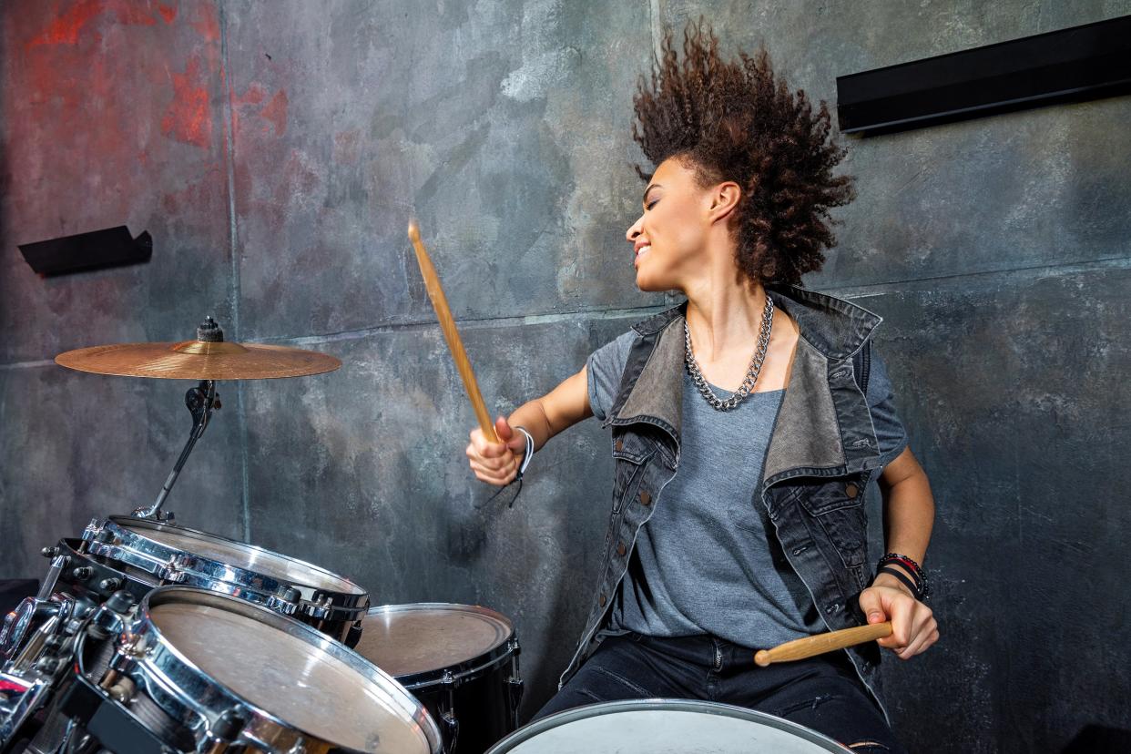 emotional woman playing drums in studio