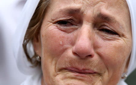 A woman cries near a truck carrying 136 coffins of newly identified victims of the 1995 Srebrenica massacre, in front of the presidential building in Sarajevo, July 9, 2015.REUTERS/Dado Ruvic