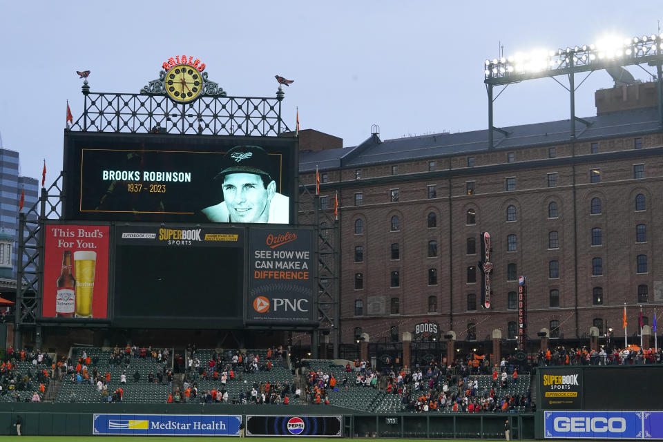 A crowd observes a moment of silence as the Baltimore Orioles honor Hall of Fame third baseman Brooks Robinson after his passing prior to a baseball game between the Orioles and the Washington Nationals, Tuesday, Sept. 26, 2023, in Baltimore. (AP Photo/Julio Cortez)