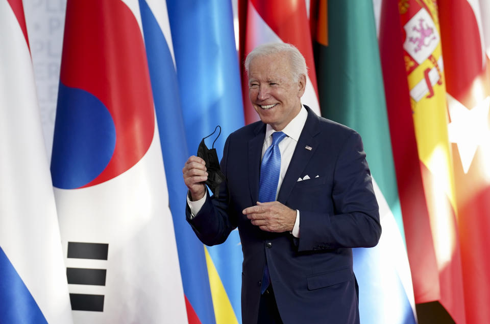 U.S. President Joe Biden takes off his protective face mask as he arrives at the La Nuvola conference center for the G20 summit in Rome, Saturday, Oct. 30, 2021. The two-day Group of 20 summit is the first in-person gathering of leaders of the world's biggest economies since the COVID-19 pandemic started. (Kevin Lamarque/Pool Photo via AP)