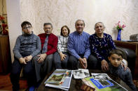 From left: Adil Sharifov's grandson Ramazan Sharifov, uncle Ramiz Humbatov, sister Kamala Sharifova, Adil Sharifov, his mother Adila Ahmadova and grandson Tariyel Sharifov pose for a photo at home in Baku, Azerbaijan, Friday, Nov. 20, 2020. Adil Sharifov, 62, who left his hometown in 1992 during the first war and lives in Azerbaijan's capital, Baku, knows he will find similar devastation if he returns to the city of Jabrayil, which he longs to do. (AP Photo/Aziz Karimov)