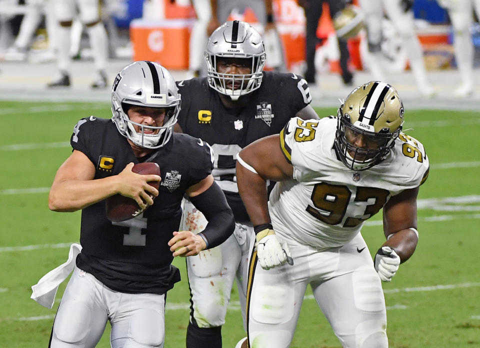 LAS VEGAS, NEVADA - SEPTEMBER 21:  Quarterback Derek Carr #4 of the Las Vegas Raiders rushes under pressure from defensive tackle David Onyemata #93 of the New Orleans Saints ahead of Rodney Hudson #61 of the Raiders during the first half of the NFL game at Allegiant Stadium on September 21, 2020 in Las Vegas, Nevada. The Raiders defeated the Saints 34-24.  (Photo by Ethan Miller/Getty Images)