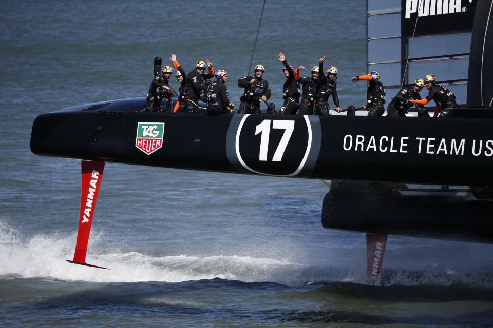 Members of Oracle Team USA wave to spectators after winning Race 17 of the 34th America's Cup yacht sailing race against Emirates Team New Zealand in San Francisco, California September 24, 2013. REUTERS/Stephen Lam (UNITED STATES - Tags: SPORT YACHTING)