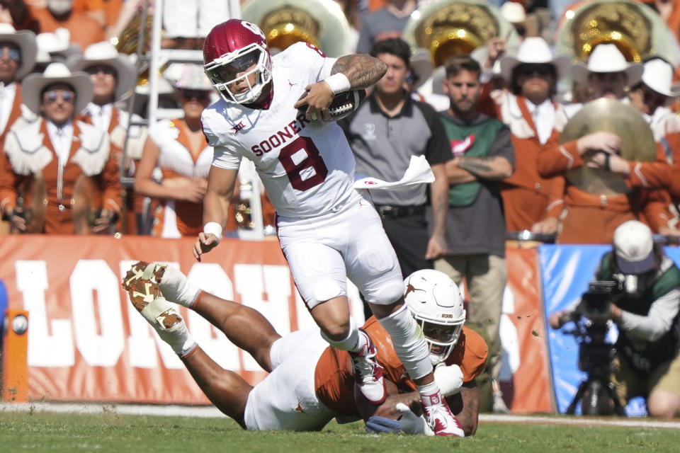 Oklahoma quarterback Dillon Gabriel (8) evades a tackle during the first half of an NCAA college football game against Texas at the Cotton Bowl in Dallas, Saturday, Oct. 7, 2023. Oklahoma is already piling up plenty of accolades in its final Big 12 season.(AP Photo/LM Otero)