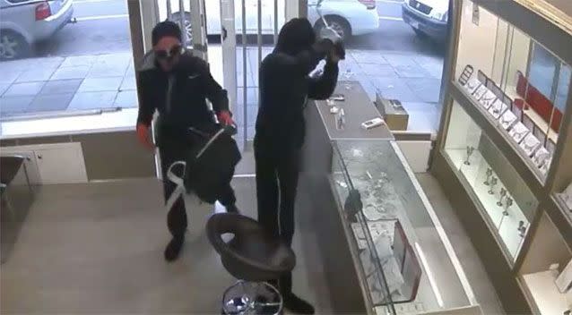 One of the men smashed a glass display cabinet with a wheel nut brace. Picture: Victoria Police