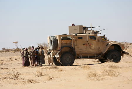 Tribal fighters loyal to Yemen's government gather next to an armoured personnel carrier during fighting against Houthi rebels in an area between Yemen's northern provoices of al-Jawf and Marib December 5, 2015. REUTERS/Ali Owidha