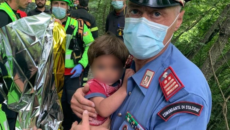 A police officer holds Nicola Tanturli, who was found after spending over 24 hours lost in the woods.