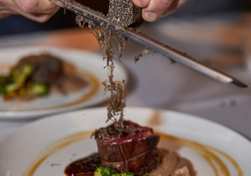 Black truffle shavings cascade over a steak course at the 2021 Palm Beach Food and Wine Festival's "First Bite" dinner at Buccan bistro in Palm Beach. While that event is sold out, others remain.