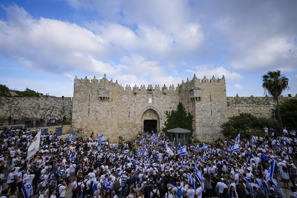 Israelis dance and wave national flags during a march marking Jerusalem Day, an Israeli holiday celebrating the capture of east Jerusalem in the 1967 Mideast war, in front of the Damascus Gate of Jerusalem's Old City, Thursday, May 18, 2023. (AP Photo/Ohad Zwigenberg)